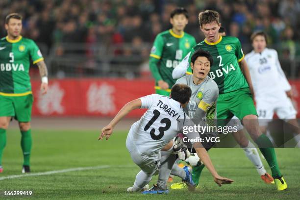 Lutfulla Turaev of Bunyodkor shoots the ball against goalkeeper Yang Zhi of Beijing Guoan battle for the ball during the AFC Champions League Group...