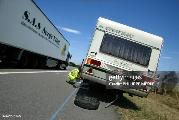 Highway security employee helps Belgian travellers on the A7 motorway near Chanas, southeastern France, 24 June 2005. Un agent de surveillance ou...