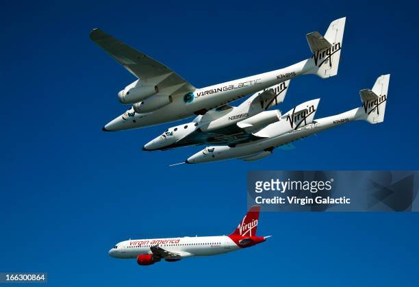 Virgin Galactic vehicles WhiteKnightTwo and SpaceShipTwo fly alongside Virgin America plane for the opening of the new Virgin America terminal at San...