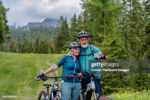 elderly cyclists resting, taking selfie, to preserve memories. - fahrrad fahren alte leute beine stock-fotos und bilder