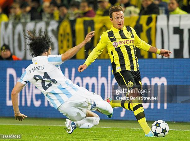 Sergio Sanchez of Malaga tackles Mario Goetze of Borussia Dortmund during the UEFA Champions League quarter-final second leg match between Borussia...