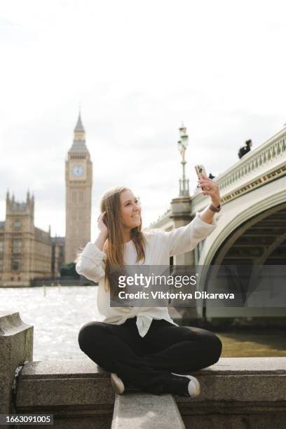 woman taking a selfie in london with the big ben. - big ben selfie stock pictures, royalty-free photos & images