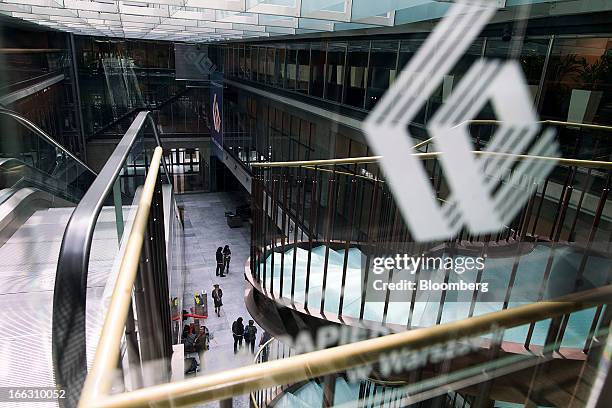 Logo sits on display above visitors in the main hall at the Warsaw Stock Exchange in Warsaw, Poland, on Thursday, April 11, 2013. Poland's central...