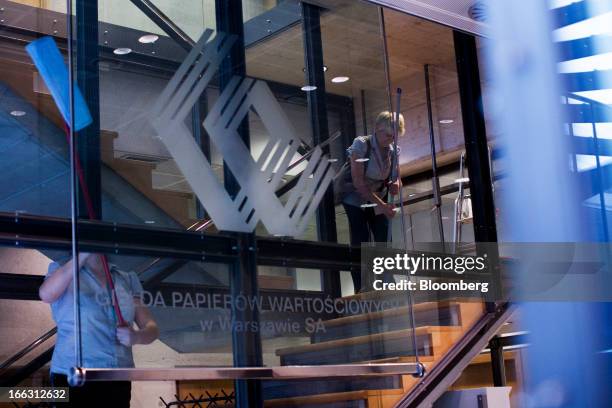 Cleaners work on a stairway displaying the WSE company logo at the Warsaw Stock Exchange in Warsaw, Poland, on Thursday, April 11, 2013. Poland's...