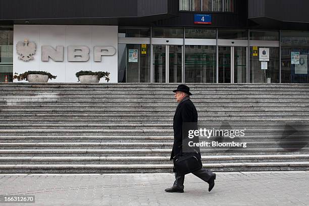 Pedestrian passes the headquarters of the National Bank of Poland in Warsaw, Poland, on Wednesday, April 10, 2013. Poland's central bank kept...