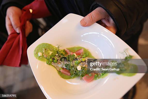 Visitor tries out herring with peas and radish on the first day of Street Food Thursday at the Markthalle Neun market hall in Kreuzberg district on...