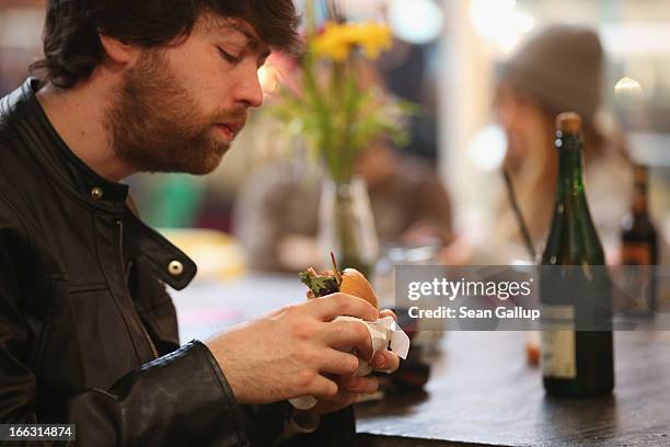 Visitor tucks into a pulled pork sandwich on the first day of Street Food Thursday at the Markthalle Neun market hall in Kreuzberg district on April...