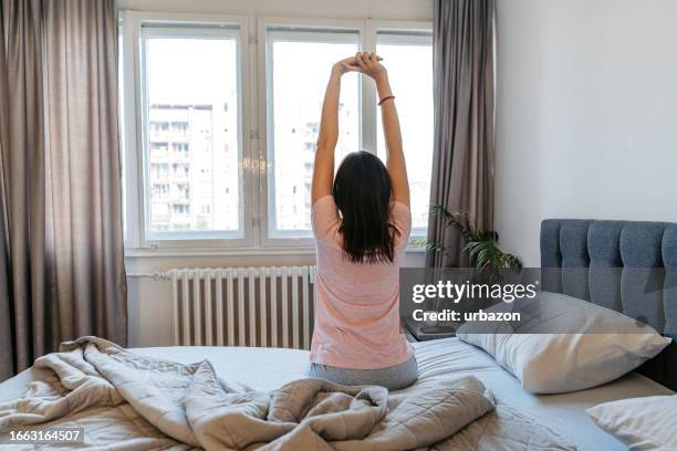 young woman waking up in the bed in the morning - overslept stock pictures, royalty-free photos & images