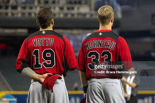 Joey Votto and Justin Morneau of Canada stand during the national anthem against Italy during the World Baseball Classic First Round Group D game on...
