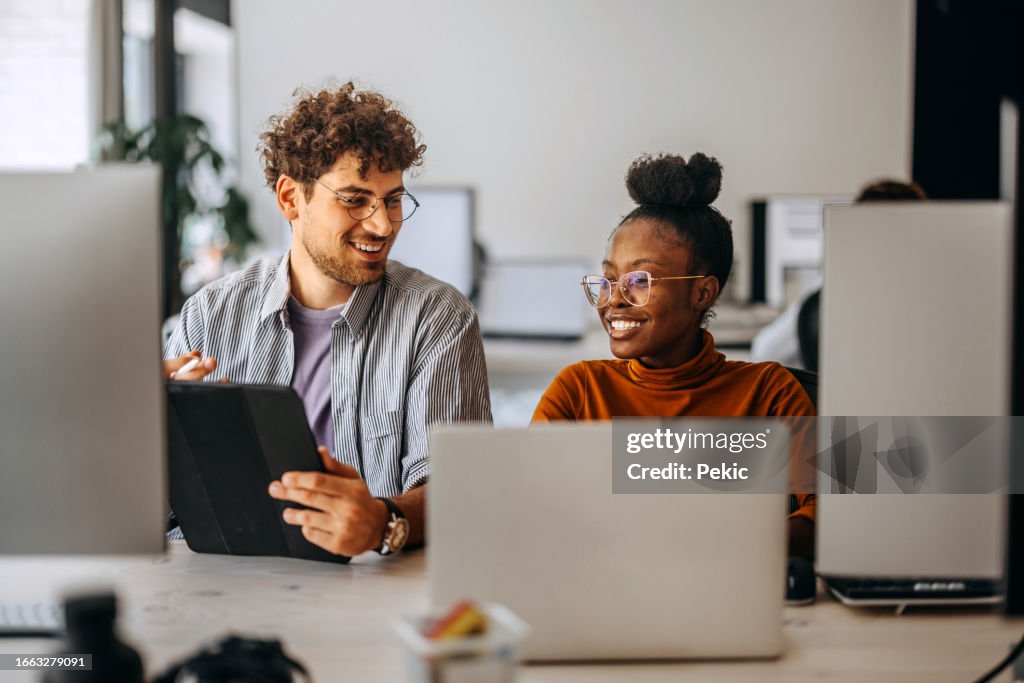 Two young colleagues working together at modern office