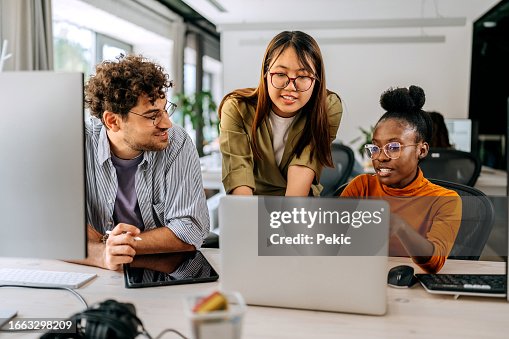 Three young colleagues discussing work at modern office Three young colleagues discussing work at modern office
