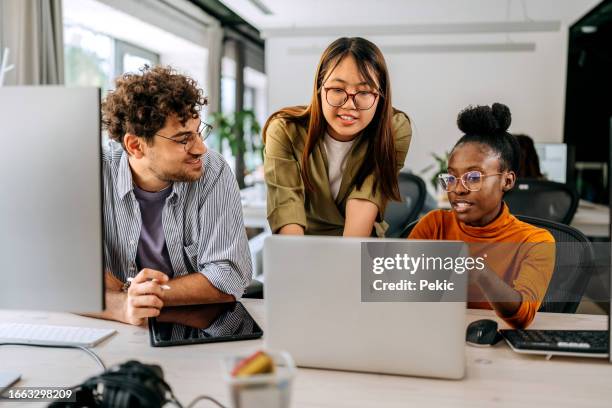 three young colleagues discussing work at modern office - ung vuxen bildbanksfoton och bilder