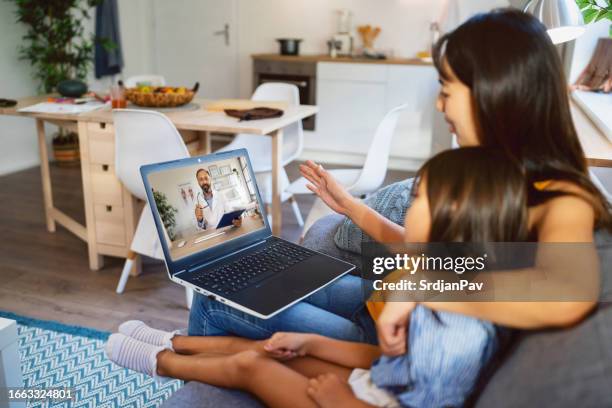 mother and daughter japanese ethnicity on a video call with pediatrician - telemedicine stock pictures, royalty-free photos & images