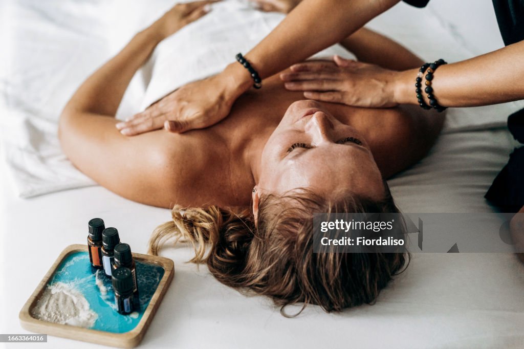 Woman massage therapist doing manual therapy to patient