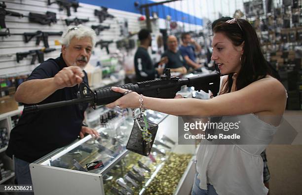 As the U.S. Senate takes up gun legislation in Washington, DC , Dr. Gary Lampert , a co-owner of the National Armory gun store, helps Cristiana Verro...