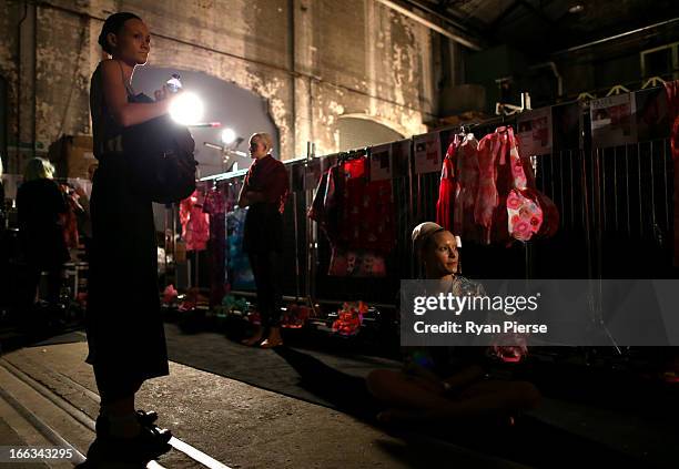 Models prepare backstage for the Romance Was Born show during Mercedes-Benz Fashion Week Australia Spring/Summer 2013/14 at Carriageworks on April 8,...