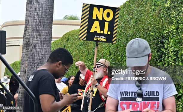 Actor, director and cinematographer Mark Gray holds a sign reading "No A.I." as writers and actors staged a solidarity march through Hollywood to...