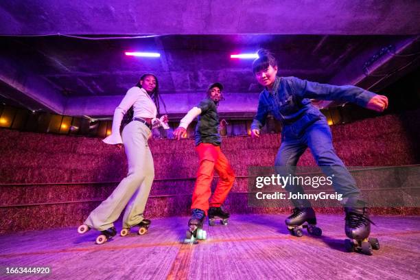 action portrait of disco dancing roller skaters - roller-skating stock pictures, royalty-free photos & images