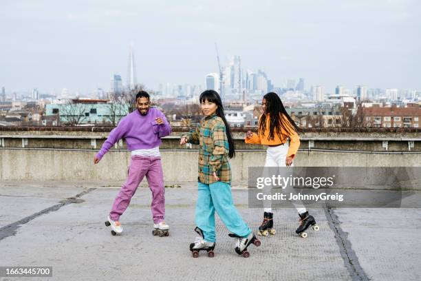 roller skating friends exercising on urban rooftop - roller skates stock pictures, royalty-free photos & images