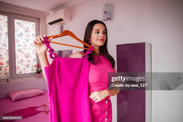 gen z girl wearing hot pink clothes, trying on a new dress - pink dress stock pictures, royalty-free photos & images