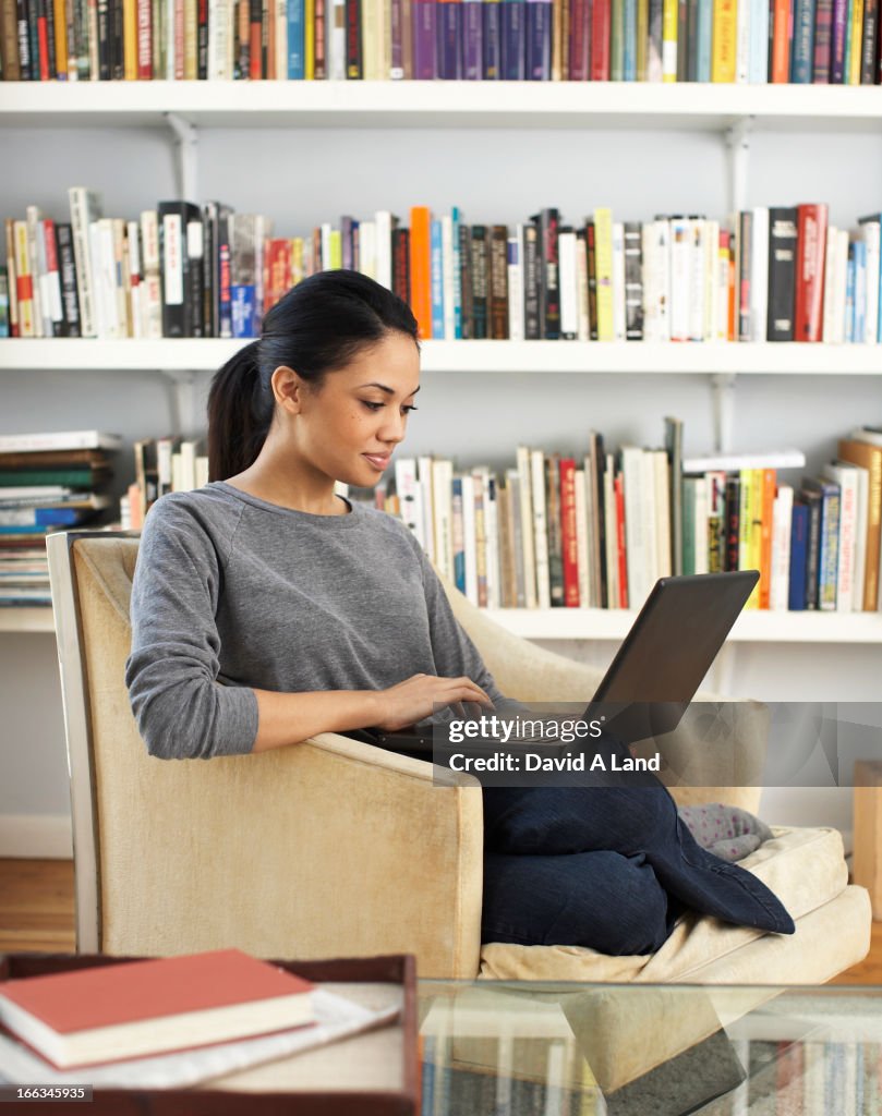 Woman sitting in chair using laptop