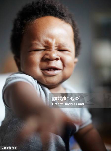 grimacing african american baby - hacer muecas fotografías e imágenes de stock