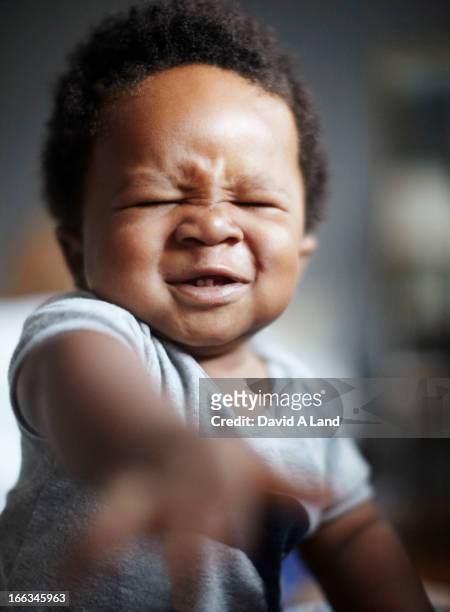 grimacing african american baby - baby attitude stock pictures, royalty-free photos & images