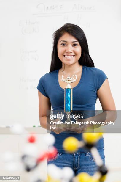 asian high school student holding trophy in classroom - teen awards stock pictures, royalty-free photos & images