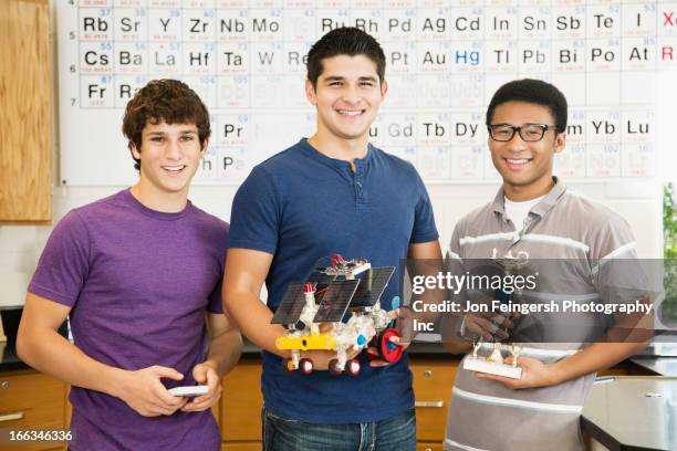 high school students holding solar powered machine and trophy - teen awards stock pictures, royalty-free photos & images