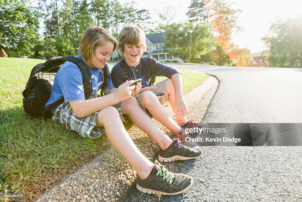 Caucasian boys looking at cell phone