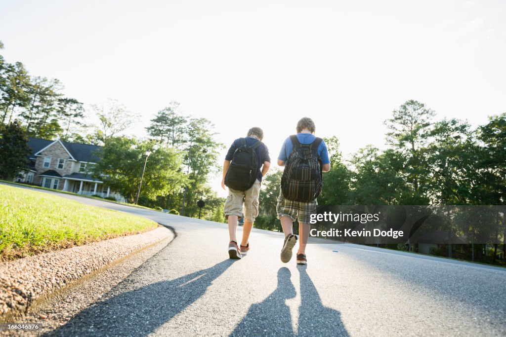 Caucasian boys walking in road