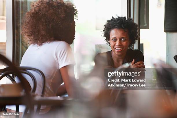 black friends sitting together in cafe - 2 frauen gespräch ohne männer cafe stock-fotos und bilder