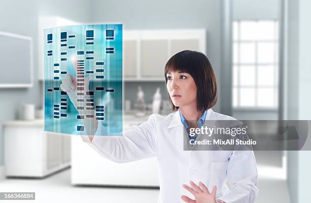 mixed race doctor using digital display in doctor's office - scientifique blouse blanche photos et images de collection