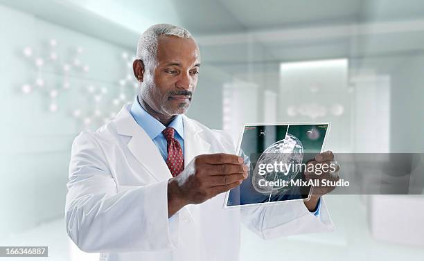 mixed race doctor using digital tablet - mixed race man standing studio stockfoto's en -beelden
