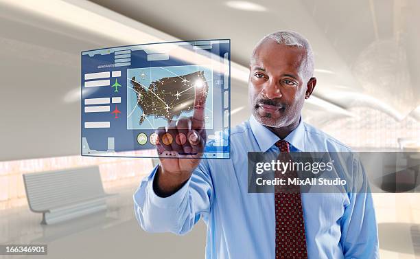 black businessman using digital display - departure board front on fotografías e imágenes de stock