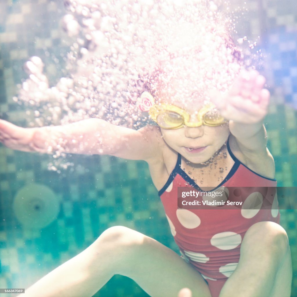Caucasian girl swimming under water