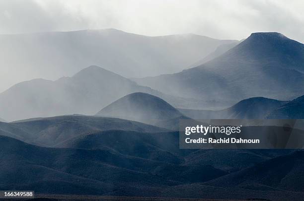 a storm engulfs the mountains in the nevada desert along highway 95. - engulfs stock pictures, royalty-free photos & images