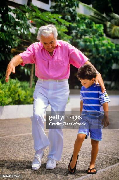 1990s Grandfather teaching his grandson a dance step.