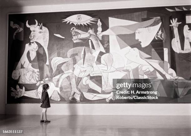 1970s Small girl looking at picasso painting guernica while on exhibit at museum of modern art new york city USA.