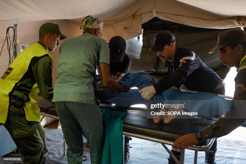 Medical workers and officers are seen moving a child to a...