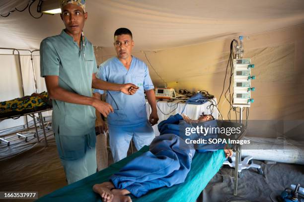 Two medical workers are seen reacting while a child is sent to the emergency tent of the military hospital. Villagers living in Imlil in the Toubkal...