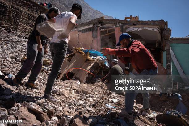 Locals are seen clearing the rubble from a destroyed house. Villagers living in Imlil in the Toubkal mountains, are still coming to terms with the...
