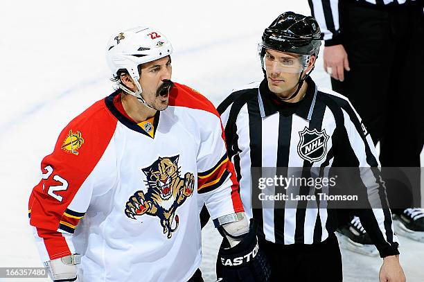 George Parros of the Florida Panthers shows his displeasure as he is escorted to the penalty box by linesman Bryan Pancich during second period...