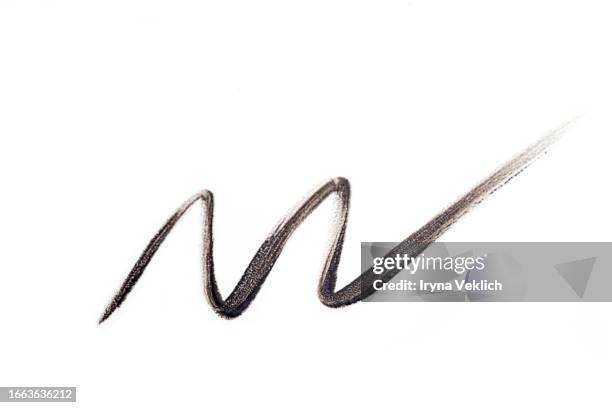 waved black smear of black eyeliner pencil or eyebrow pencil on white background, isolated. cosmetic make-up product for eye and eyelashes. - kajalschminke stock-fotos und bilder