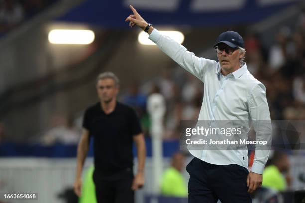 Laurent Blanc Head coach of Olympique Lyon reacts as Luis Enrique Head coach of PSG looks on in the background during the Ligue 1 Uber Eats match...