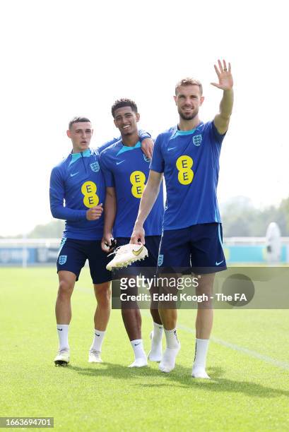 Jude Bellingham, Jordan Henderson and Phil Foden of England talk during a training session at St George's Park on September 06, 2023 in Burton upon...