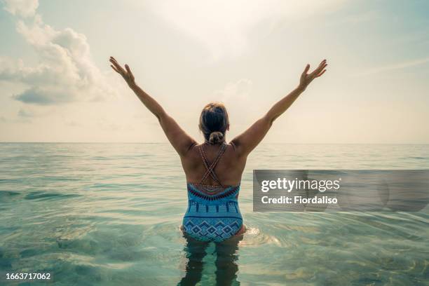 middle age woman standing in the ocean - tears of joy stock pictures, royalty-free photos & images