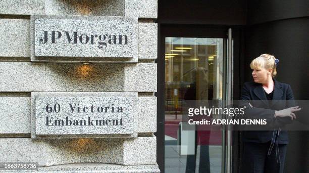 An employee smokes a cigarette outside the office of JP Morgan in London 15 January 2004. The company have announced plans to merge with US retail...