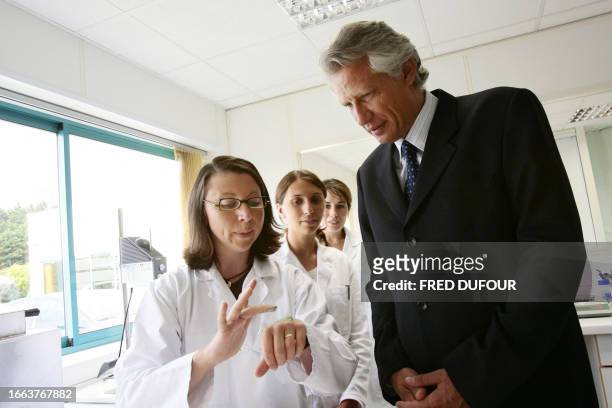 Le Premier ministre Dominique de Villepin écoute les bienfaits d'une crème expliqués par des employées de l'usine Agrimer, le 20 juillet 2006 à...