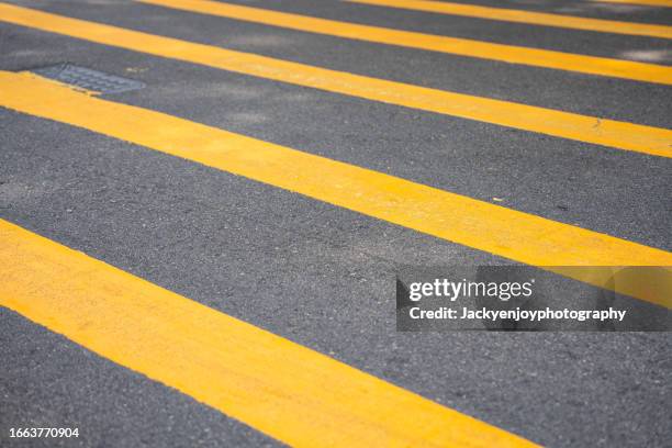 pedestrian crossing with yellow stripes on an asphalt road - pedestrian crossing sign stock pictures, royalty-free photos & images